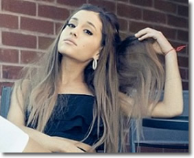 Ariana Grande stares you down as she shows you some of her pretty hair. Maybe you like?